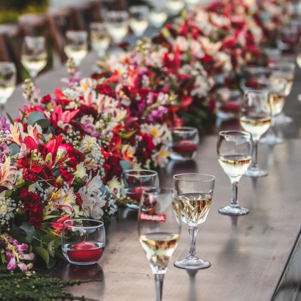 a row of wine glasses sitting on top of a wooden table