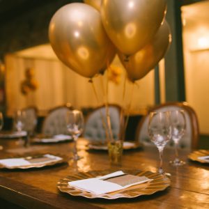 Photo by Nathalia Segato gold balloons on brown wooden table